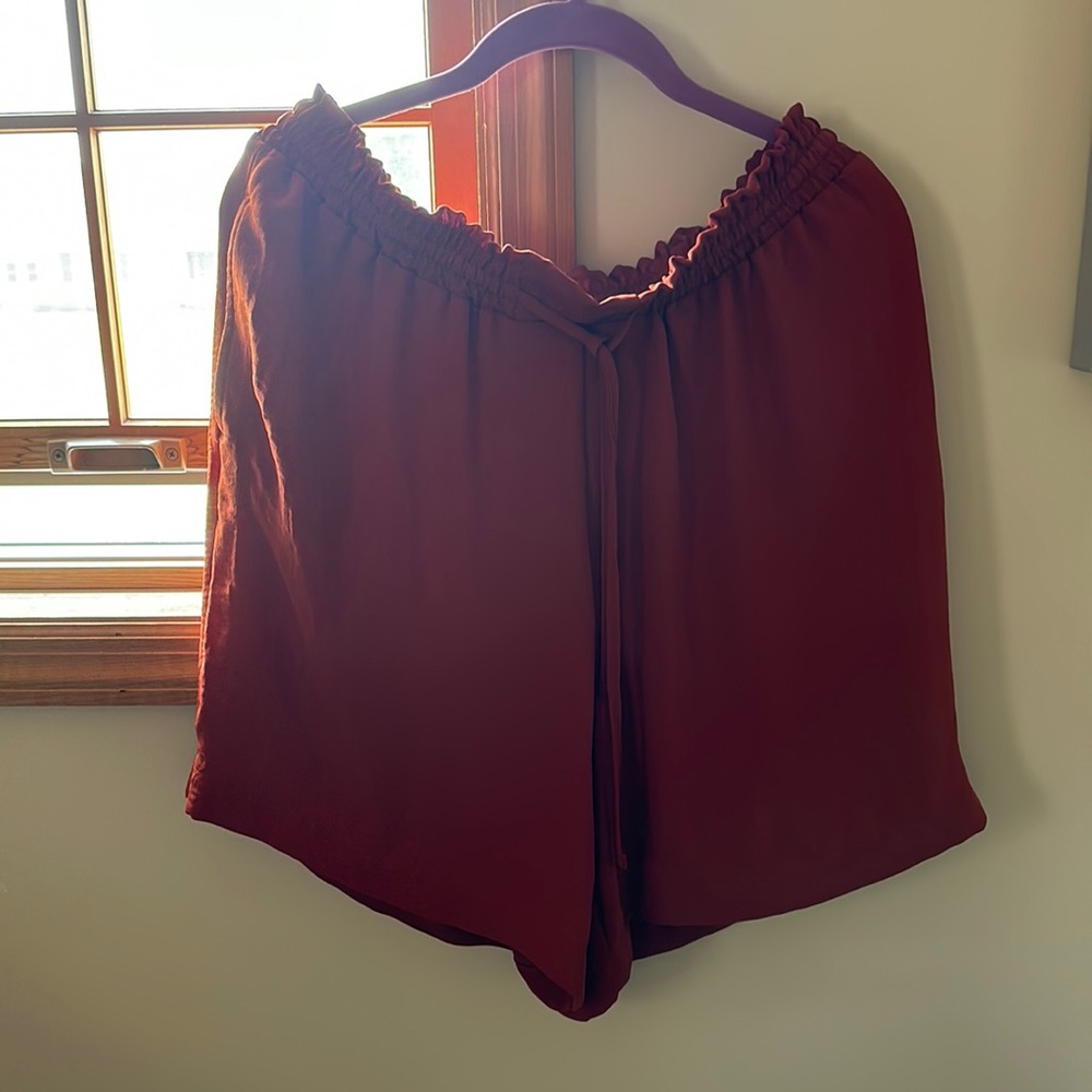 Orangish/red flowy shorts that lay right about knee cap